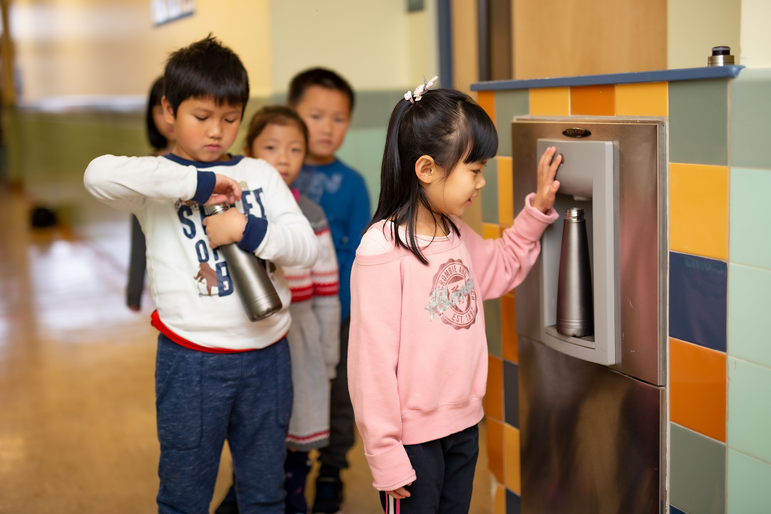 Kids getting in line to get to the water dispenser