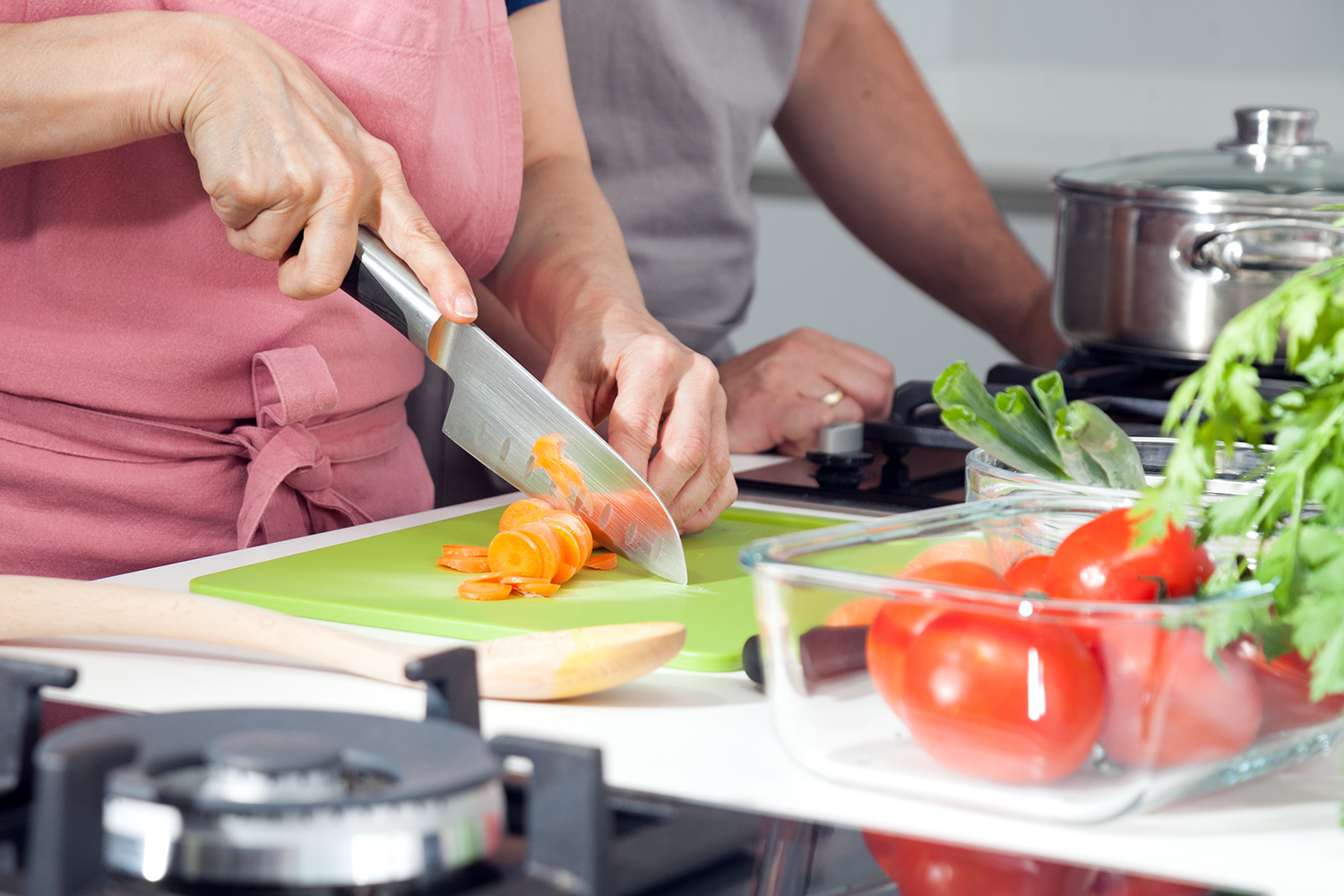 Two people cutting vegetables